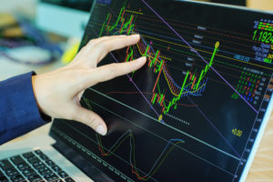 man analysing charts on laptop